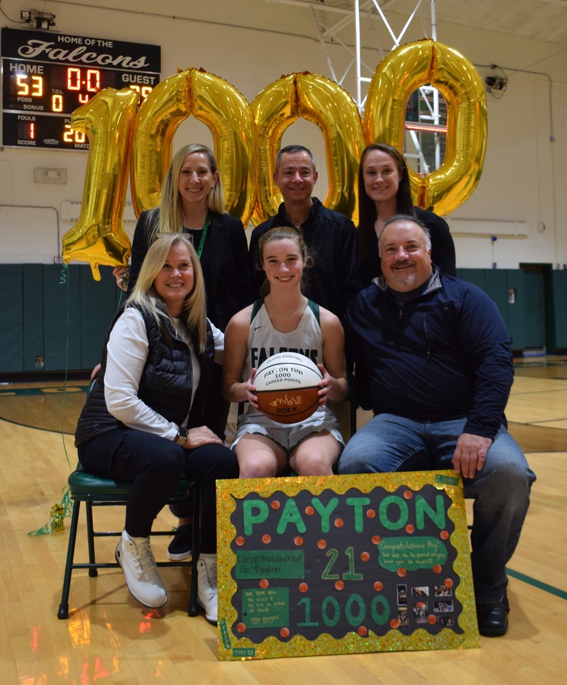 Locust Valley High School senior and starting point guard Payton Tini, center, celebrates her achievement with (seated left-right) parents Cookie and Ed, (standing) Athletic Director Danielle Turner, Head Coach Michael Guidone and Assistant Coach Carolyn Morales.