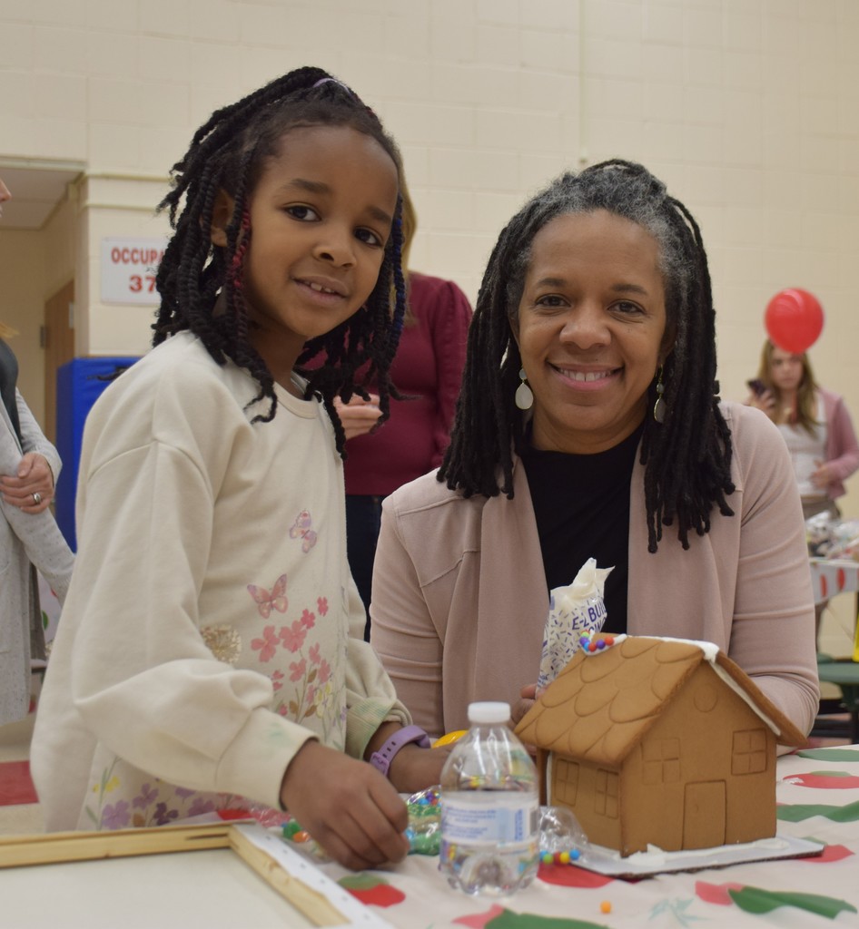 An AMP student and her mother build a gingerbread house together.
