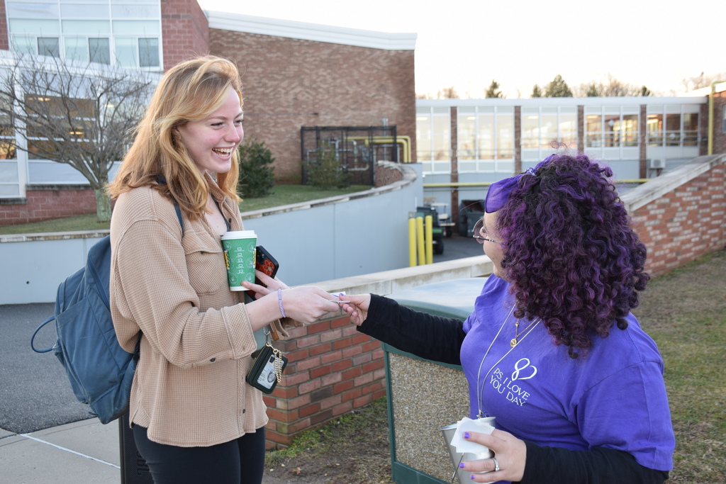 1)	Locust Valley High School student Olivia Del Tatto receives a purple heart from school social worker Bidania Criscuolo on P.S. I Love You Day.