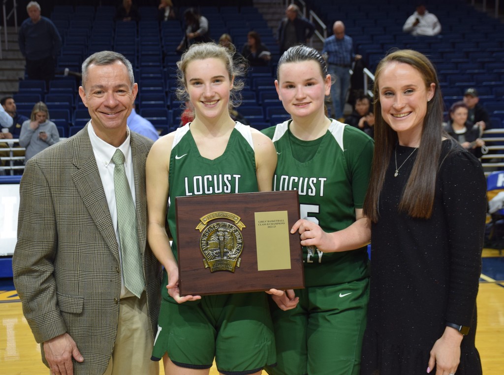 Coach Mike Guidone, guards Payton Tini and Reily Roberts and Assistant Coach Carolyn Morales celebrate the Nassau County Class B title.